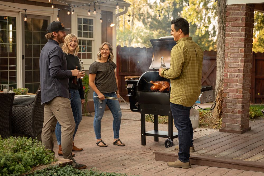 Happy group of friends enjoying a KegLand BBQ and Electric Pizza Oven gathering outdoors, enjoying delicious food and creating lasting memories in a vibrant and inviting setting